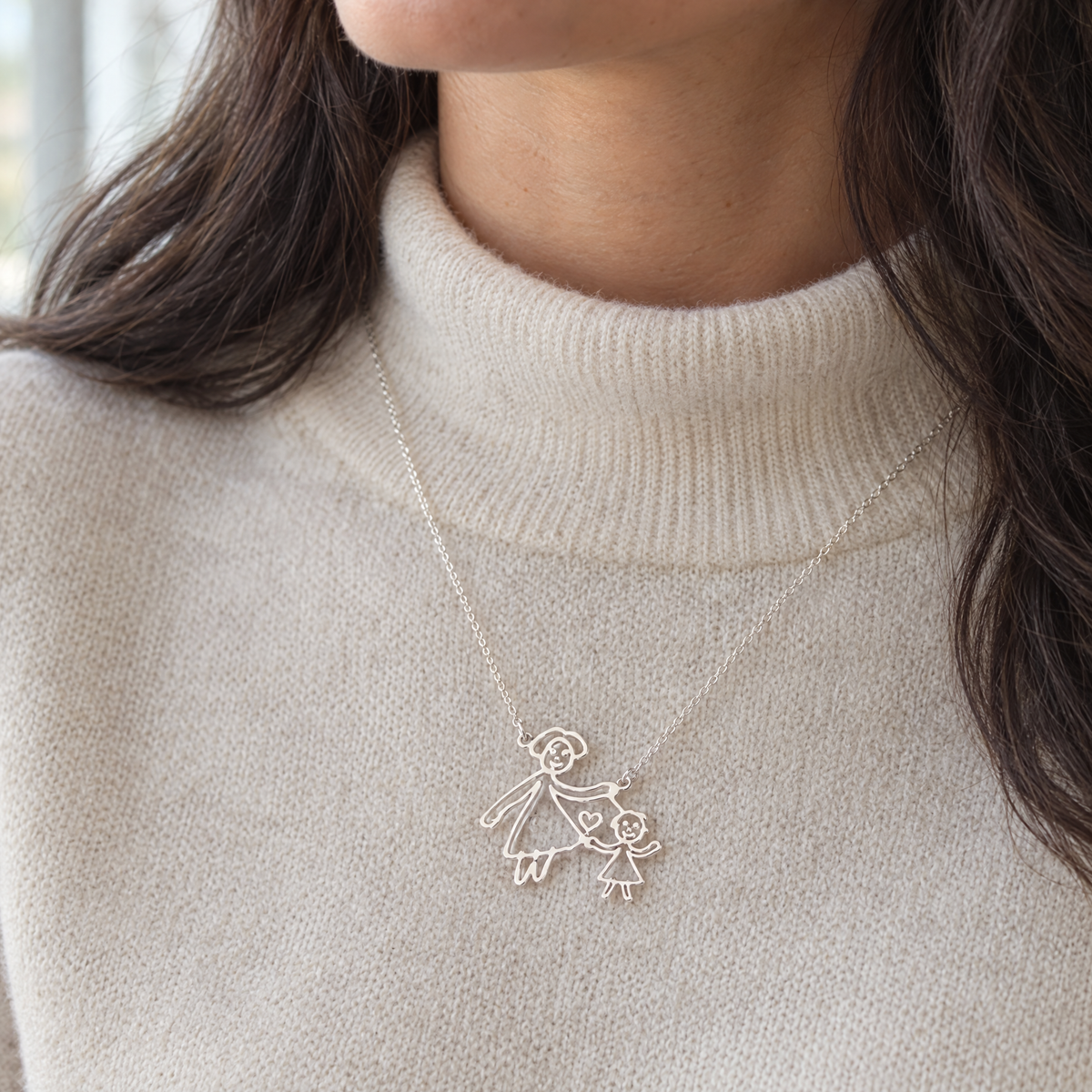 Mujer con el collar plateado con el dibujo de su hijo