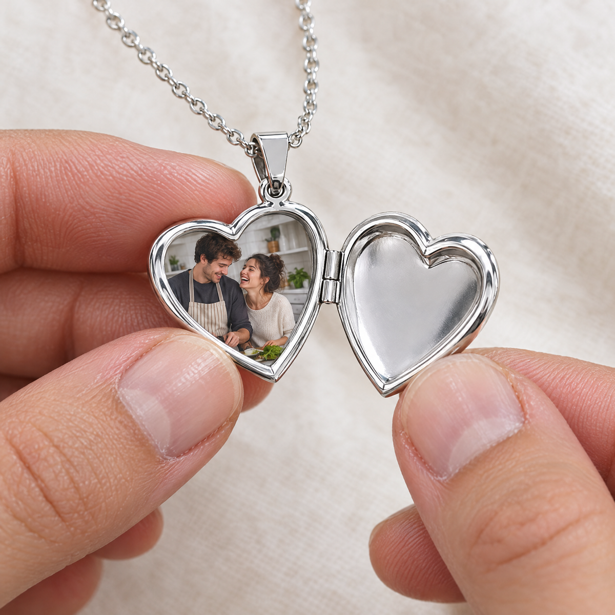 Dedos abriendo el collar de corazón plateado con la foto de una pareja dentro