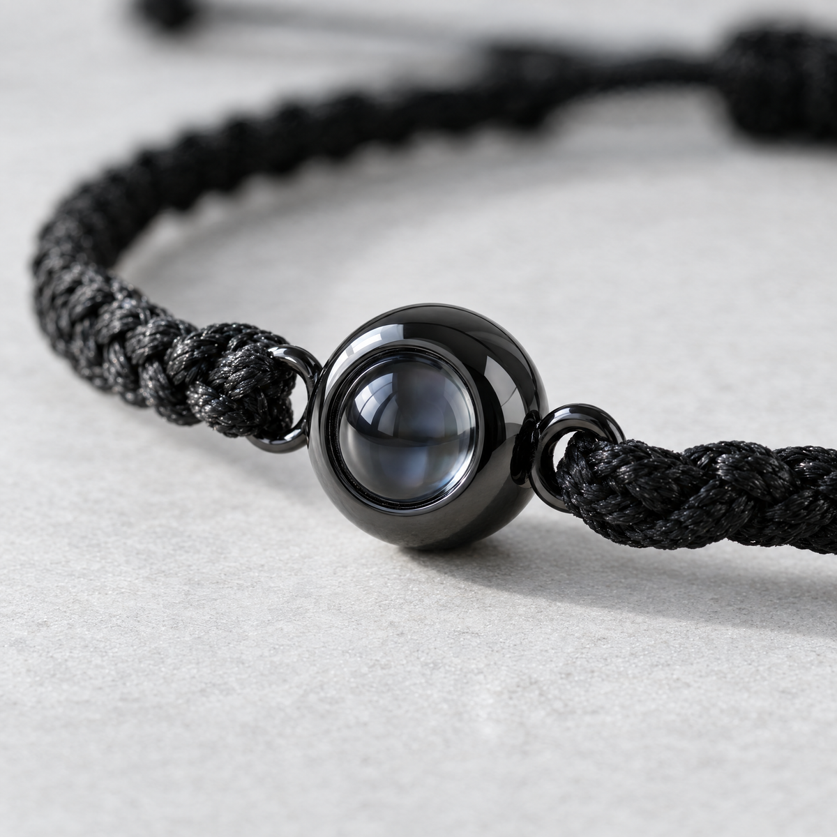 Detalle de la mirilla de acero y la cuerda trenzada de la pulsera con foto