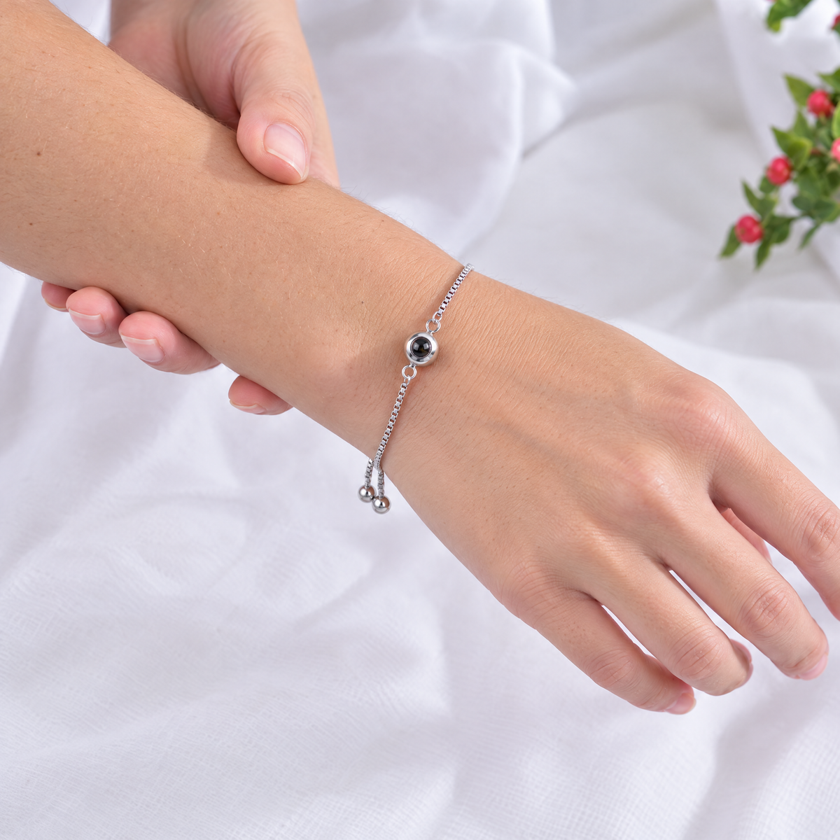 Mano con la pulsera ajustable plateada con una foto dentro