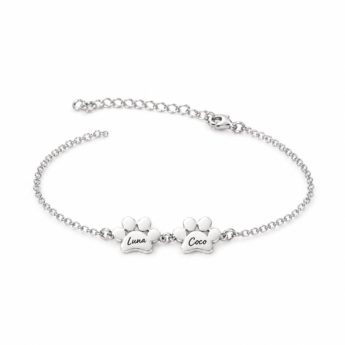 Pulsera plateada con dos huellas grabadas con los nombres Luna y Coco
