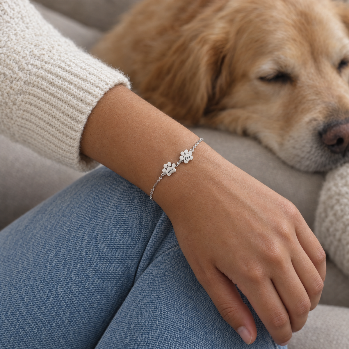 Muñeca con la pulsera plateada de dos huellas grabadas con los nombres Luna y Coco