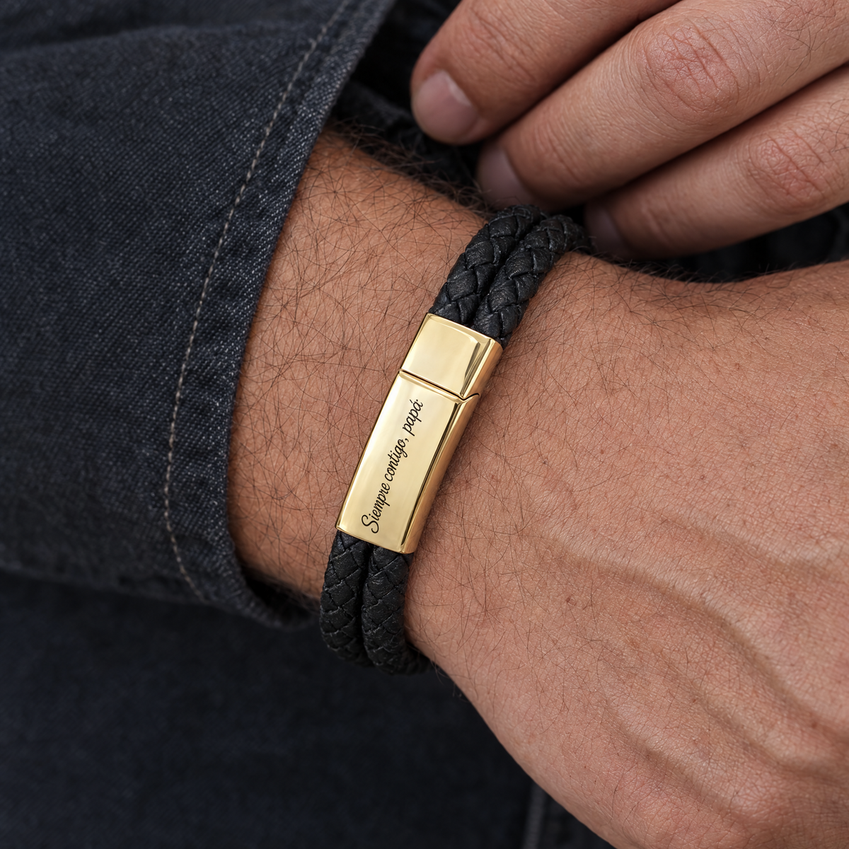 Muñeca de hombre con la pulsera de cuero trenzado y hebilla dorada grabada