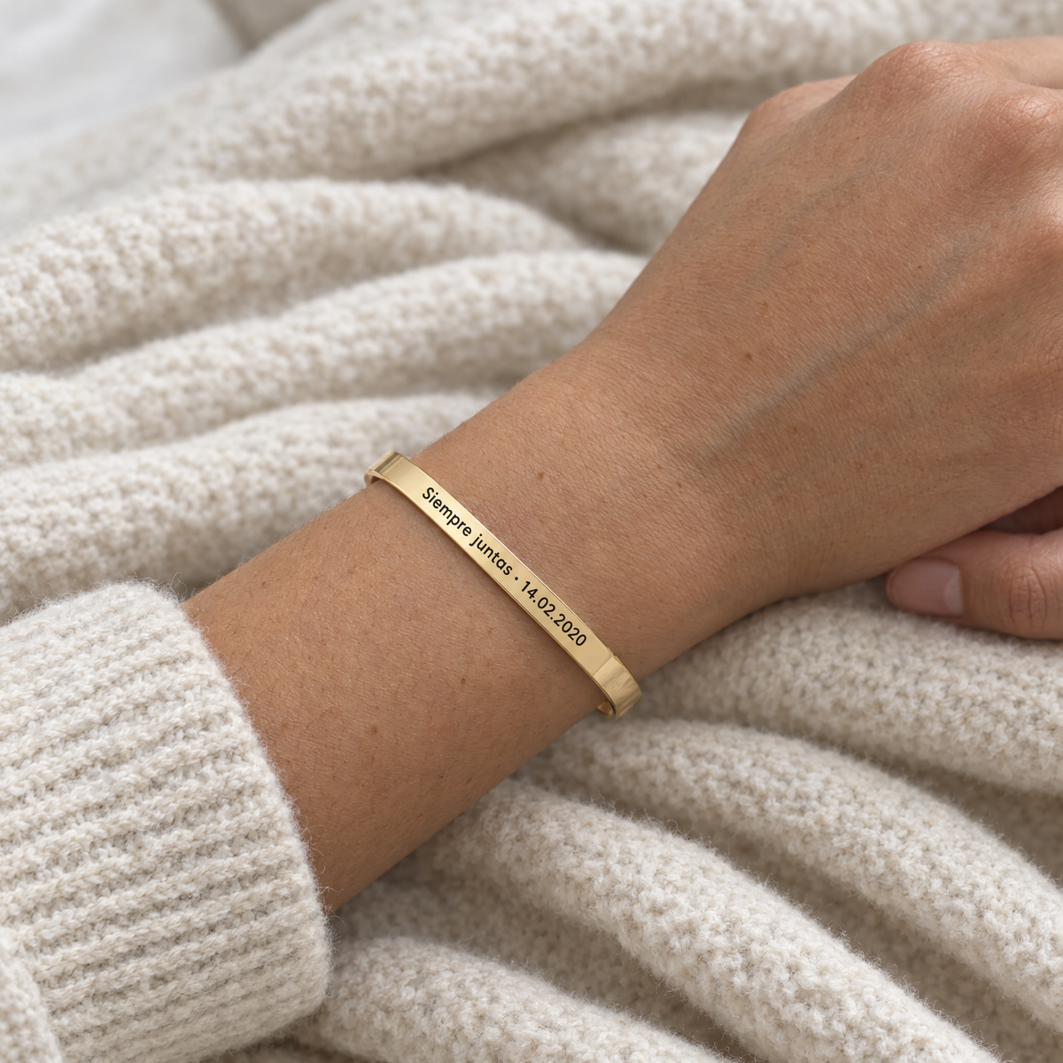 Muñeca con el brazalete dorado grabado con Siempre juntas y una fecha